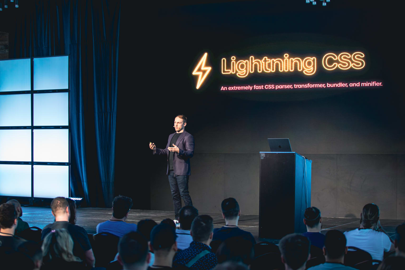 Adam Wathan on stage in front of a slide that says "Lightning CSS"
